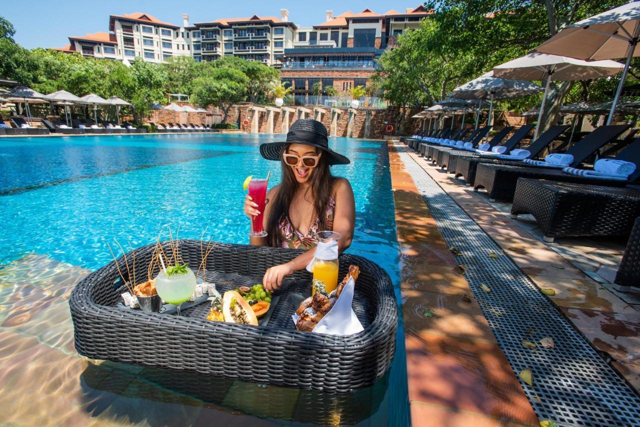 The Capital Zimbali Hotel Ballito Eksteriør billede A woman at a poolside lounge